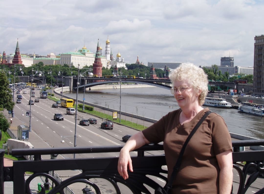 Köprüde poz veren bir kadının ardında Kremlin ve Moskova Nehri kıyısı