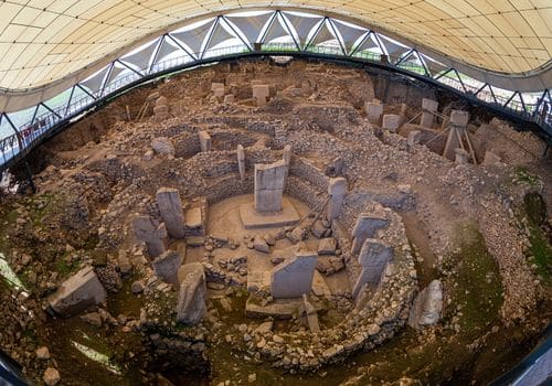 Göbeklitepe'de koruyucu çatının altındaki T biçimli sütunlardan oluşan taş daireler.