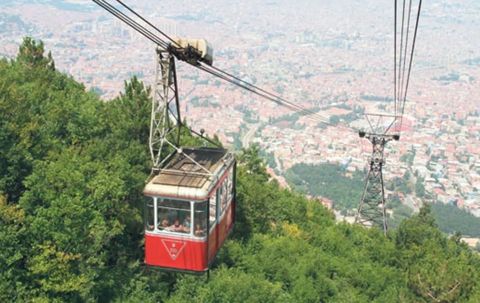 Red Uludağ cable car cabin above the forested slopes near Bursa